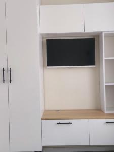 a living room with a tv and white cabinets at Studio Room in Chişinău
