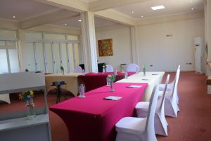 a conference room with red tables and white chairs at Maya Villa in Oyibi +102 photos