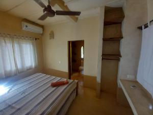 a bedroom with a bed and a ceiling fan at Marlin room in Watamu
