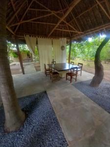 a patio with a table and chairs under a roof at Marlin room in Watamu