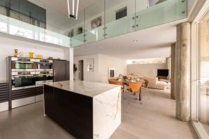 a kitchen and living room with a counter and a table at Exclusive Duplex Mansion with Sauna & Pool in Charlottenlund
