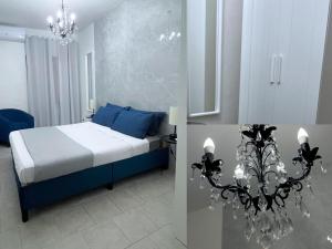 a bedroom with a bed with blue pillows and a chandelier at Casa delle Belle Donne in Pisa