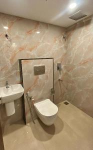 a bathroom with a toilet and a sink at Tresor Hotel in Cochin