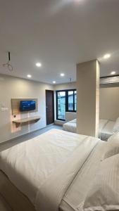 a large bedroom with two beds and a flat screen tv at Tresor Hotel in Cochin +17 photos