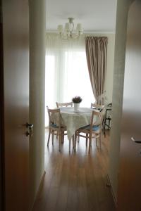 d'une salle à manger avec une table, des chaises et une fenêtre. dans l'établissement Full House Apartments, à Druskininkai