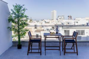 a table and chairs on a balcony with a view of a city at St Julians`s Charm Apartments in Is-Swieqi