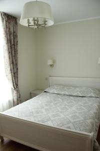 1 cama blanca en un dormitorio con ventana en Full House Apartments en Druskininkai