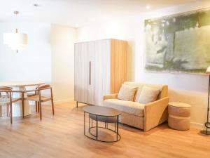 a living room with a couch and a table at AppartHotel Mercure Paris Boulogne in Boulogne-Billancourt