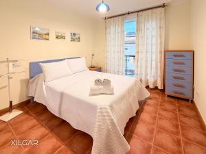 a bedroom with a white bed with towels on it at Xilgar - Chalet Ensenada de Lanzada in Sanxenxo +34 photos