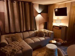 a living room with a couch and a television at Camping in de Bongerd - Kust&Q in Oostkapelle