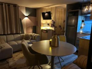 a small living room with a table and a kitchen at Camping in de Bongerd - Kust&Q in Oostkapelle +14 photos