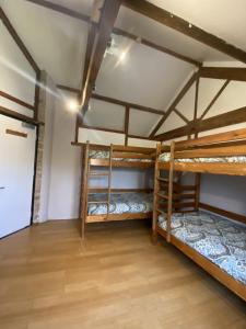 two bunk beds in a room with a wooden floor at Magdalen The Old Dairy in Winsham