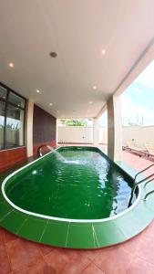 a large pool of green water in a building at Maya Villa in Oyibi
