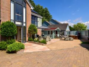 a patio of a house with chairs and an umbrella at 5 Bed in Braunton oc-78250 in Braunton