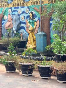 a statue of a woman in front of a mural at Millennium Hotel in Jaffna