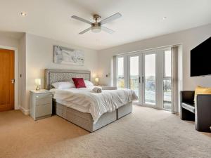 a bedroom with a bed and a ceiling fan at 5 Bed in Braunton oc-78250 in Braunton
