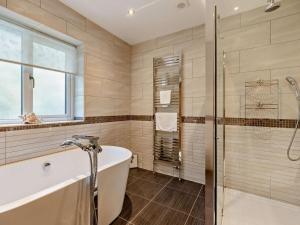 a bathroom with a tub and a glass shower at 5 Bed in Braunton oc-78250 in Braunton +37 photos