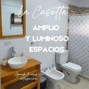 a bathroom with a toilet and a sink and a mirror at La Amanecida Tilcara Cabañas in Tilcara