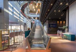 an escalator in a building with chairs and tables at Barceló Malaga in Málaga +94 photos