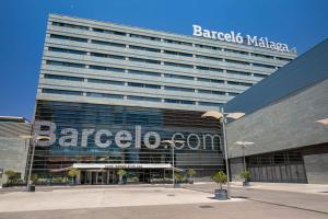 a large building with a sign on the side of it at Barceló Malaga in Málaga