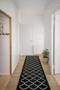 a hallway with a black and white rug on the floor at 1-Bedroom Apartment with Sauna in Heinola