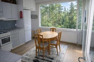 a kitchen with a table and chairs and a large window at 1-Bedroom Apartment with Sauna in Heinola