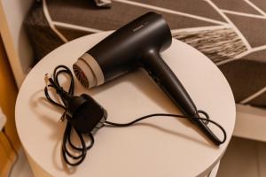 a black hair dryer sitting on a white table at St Julians`s Charm Apartments in Is-Swieqi
