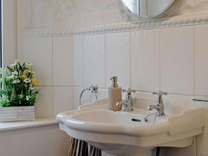 a white bathroom with a sink and a mirror at 3 Bed in Brampton oc-89994 in Slaggyford +17 photos
