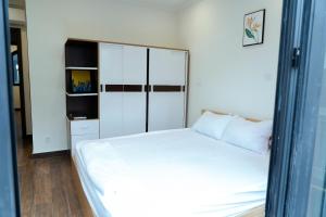 a bedroom with a white bed and a cabinet at My Sweet House in Hòa Bình