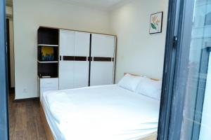 a small bedroom with a white bed and a window at My Sweet House in Hòa Bình