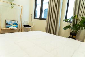 a bedroom with a large white bed and windows at My Sweet House in Hòa Bình +1 photo