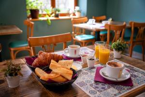 a table with a breakfast of bread and coffee and orange juice at L'Azimut in Senez