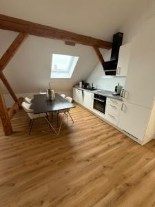 a kitchen with a table in the middle of a room at ღLIBORIA I Loft am Riegsee in Aidling