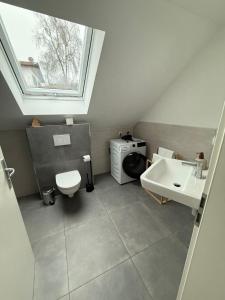 a bathroom with a sink and a toilet and a window at ღLIBORIA I Loft am Riegsee in Aidling