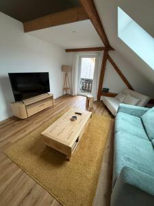 a living room with a couch and a coffee table at ღLIBORIA I Loft am Riegsee in Aidling