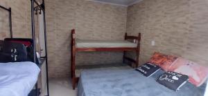 a small room with two bunk beds in it at Casa reformada com Wi-Fi, garagem e lavanderia in Capão da Canoa