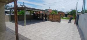 a patio with a wooden gate and a fence at Casa reformada com Wi-Fi, garagem e lavanderia in Capão da Canoa