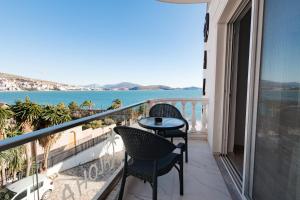 a balcony with a table and chairs and the ocean at Hotel Aloha in Sarandë