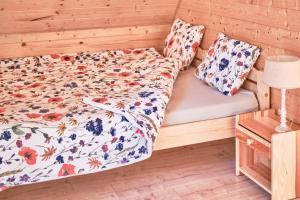 a bed in a room with a wooden wall at Domek Sol Wilcza Zagroda in Kudowa-Zdrój +21 photos