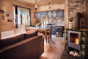 a kitchen with a fireplace and a table in a room at Domek Sol Wilcza Zagroda in Kudowa-Zdrój
