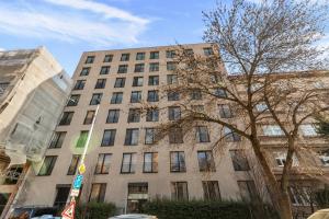 a tall building with a tree in front of it at LAM Western AC in Bratislava