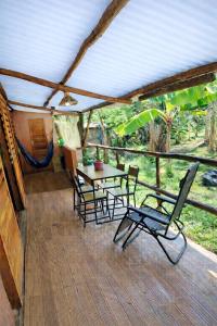 a patio with a table and chairs on a deck at Casa Cacau Boipeba in Ilha de Boipeba
