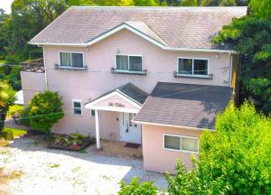 a pink house with a porch and a garage at ラシェール 伊豆 ガーデンテラス AWA Resort in Ito +24 photos