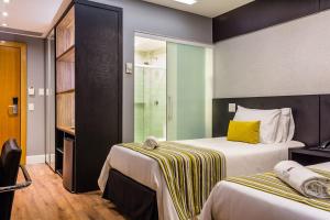 a hotel room with a bed and a dresser at Vogue Hotel Rio in São João de Meriti