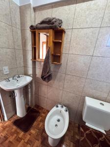 a bathroom with a toilet and a sink at Raíces Vivas Selva Misionera in Oberá