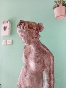 a statue of a bear standing next to a wall at Garda City Home Family Apartments in Garda