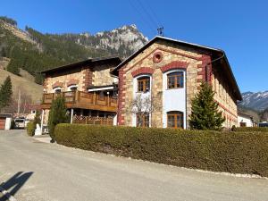 a large brick house on a street next to a mountain at Sleep-box Radwerk 14 in Vordernberg