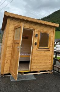 a wooden shed with a door and a window at Sleep-box Radwerk 14 in Vordernberg