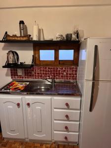 a kitchen with white cabinets and a white refrigerator at Raíces Vivas Selva Misionera in Oberá