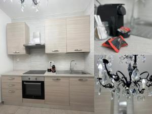 a kitchen with wooden cabinets and a sink and a chandelier at Casa delle Belle Donne in Pisa
